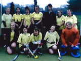 A team posing in two rows reciving a medal