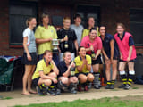 A team posing infront of a goal with the goal keeper laying down infront