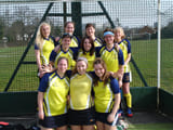 A team posing infront of a green metal fence